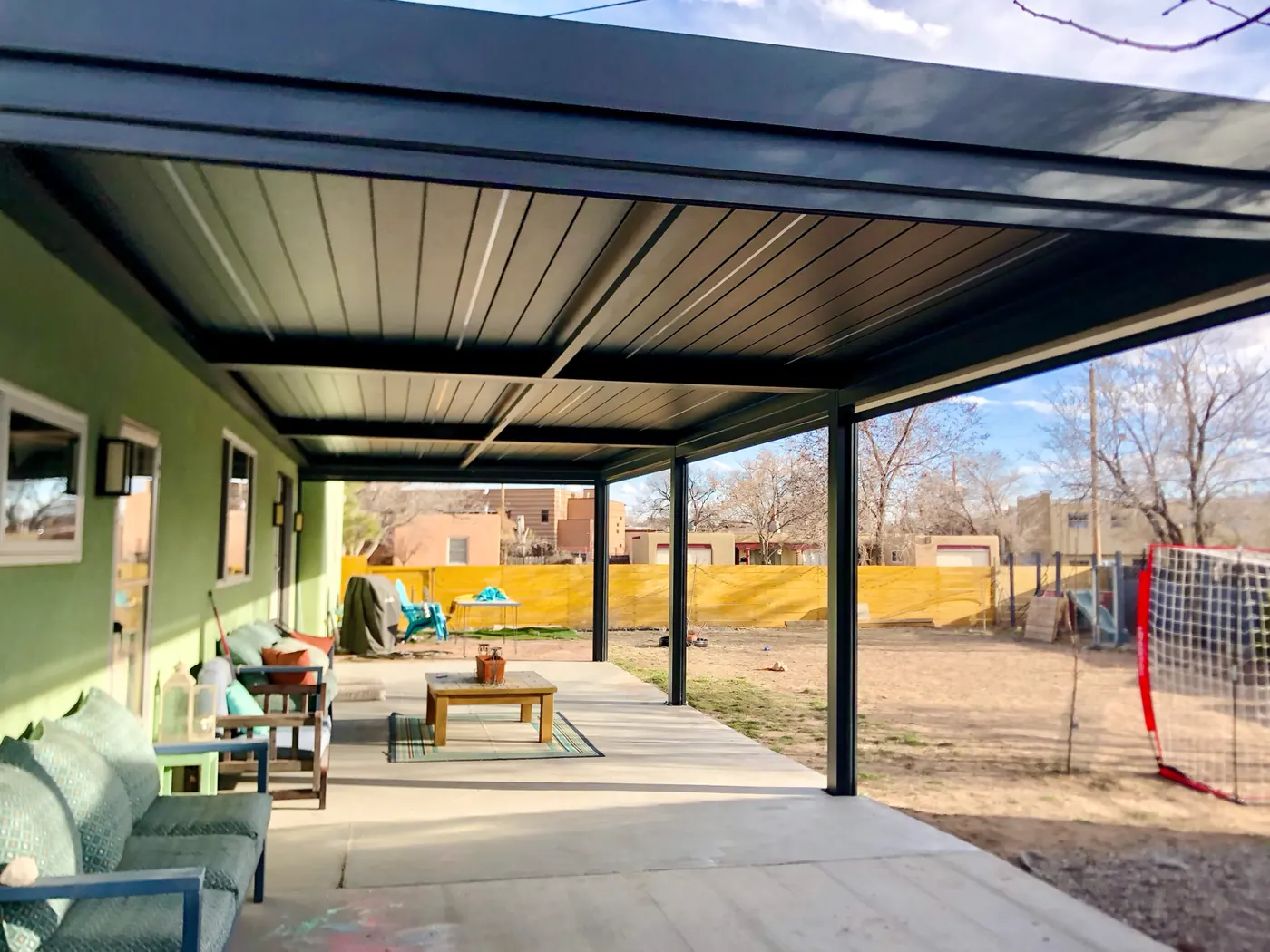 Grande pergola bioclimatique adossée couvrant une terrasse