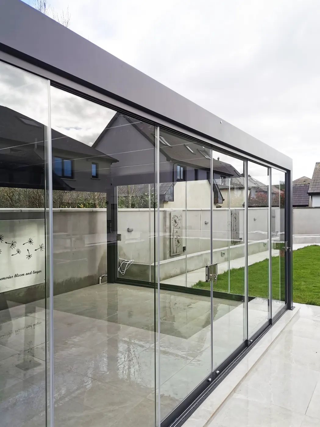 Pergola bioclimatique vitrée sur une terrasse carrelée
