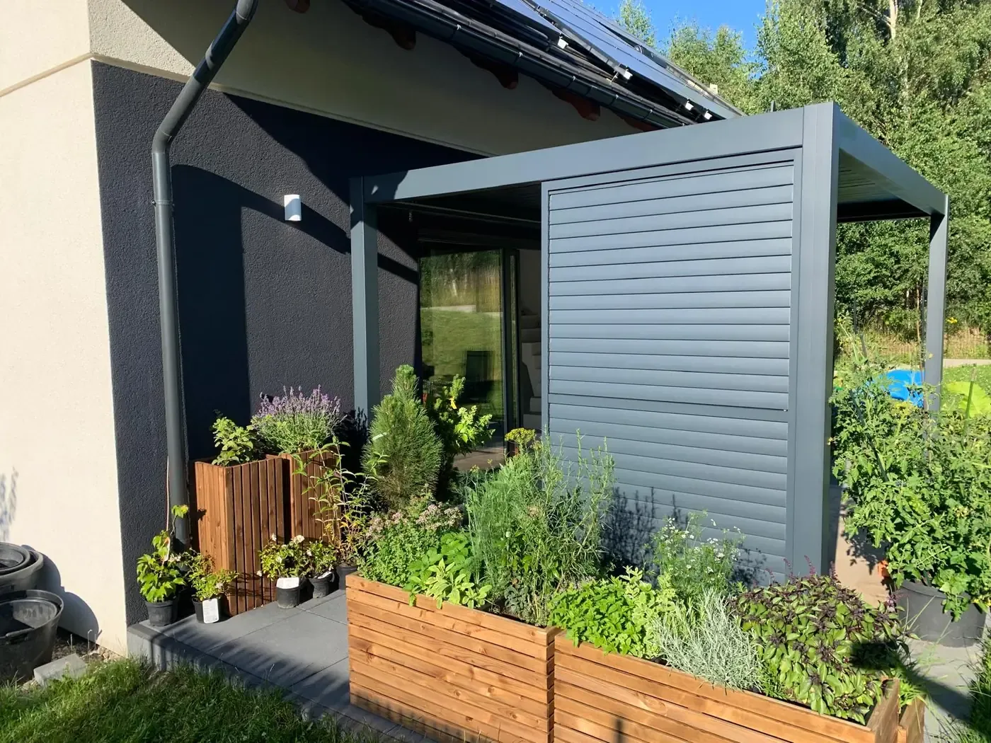 Pergola bioclimatique avec persienne latérale, jardinières au pied