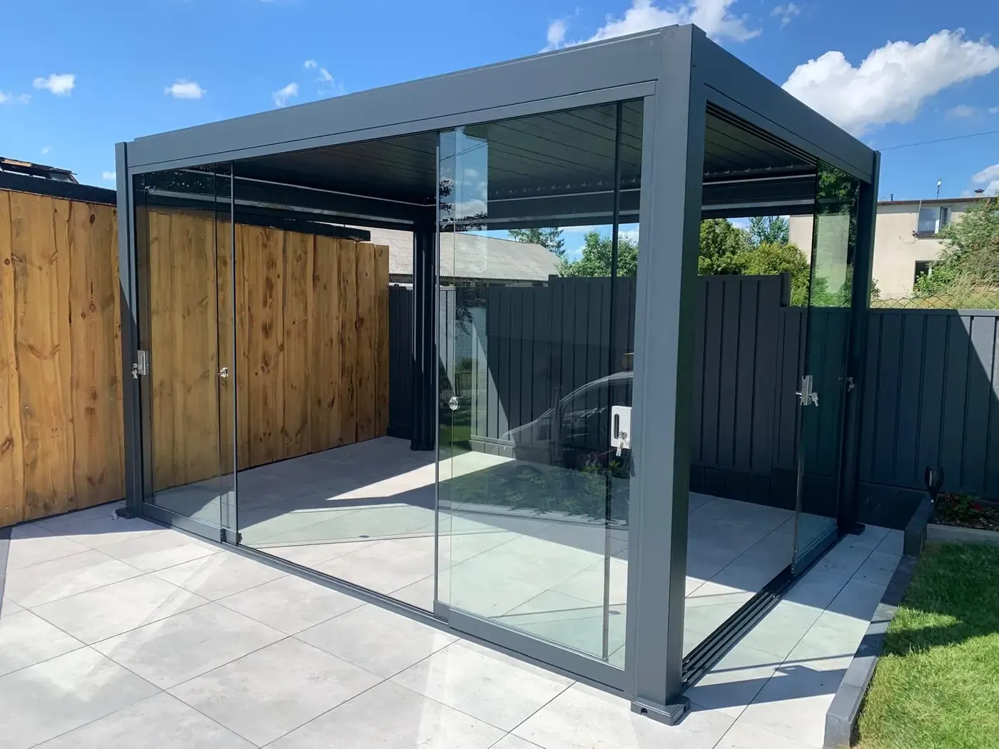 Pergola bioclimatique vitrée entre deux palissades
