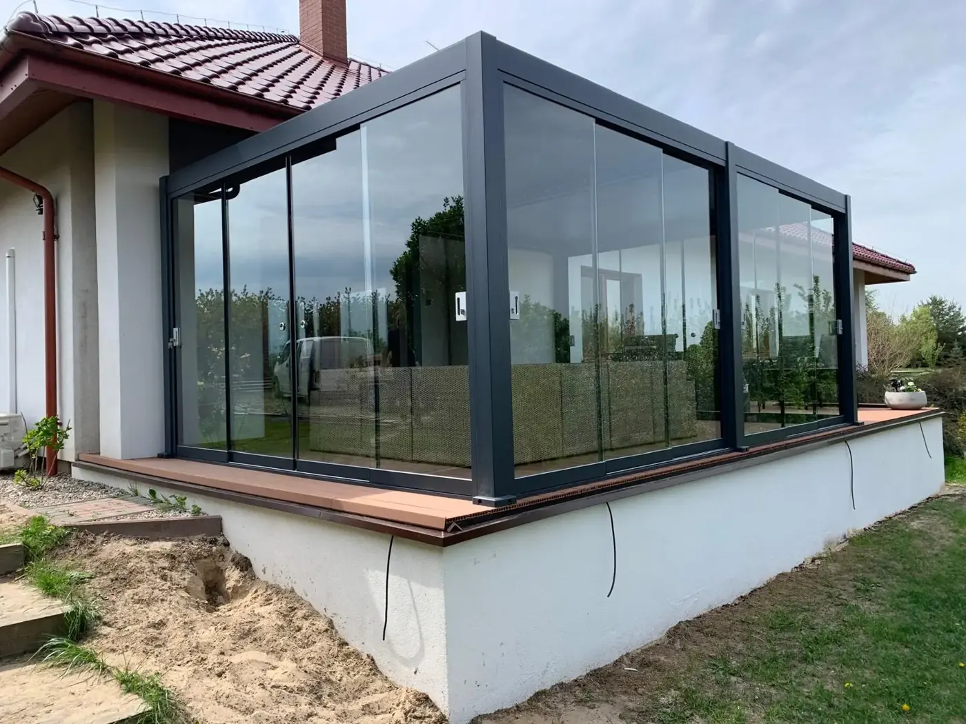 Pergola bioclimatique vitrée posée sur un soubassement