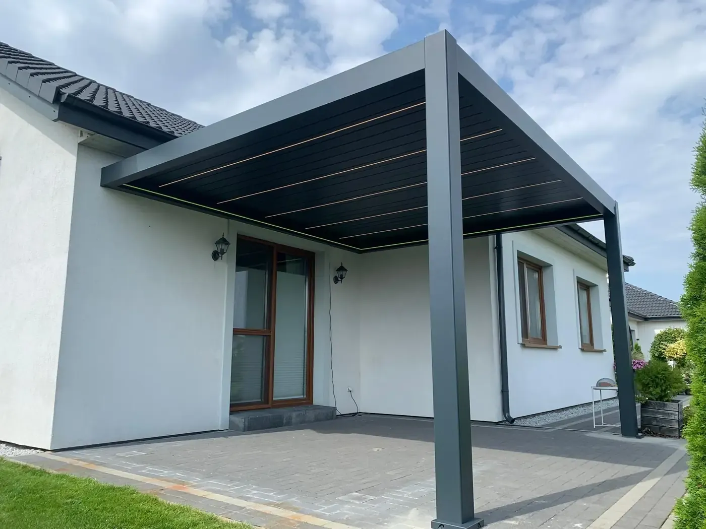 Pergola bioclimatique adossée à la maison, lames fermées