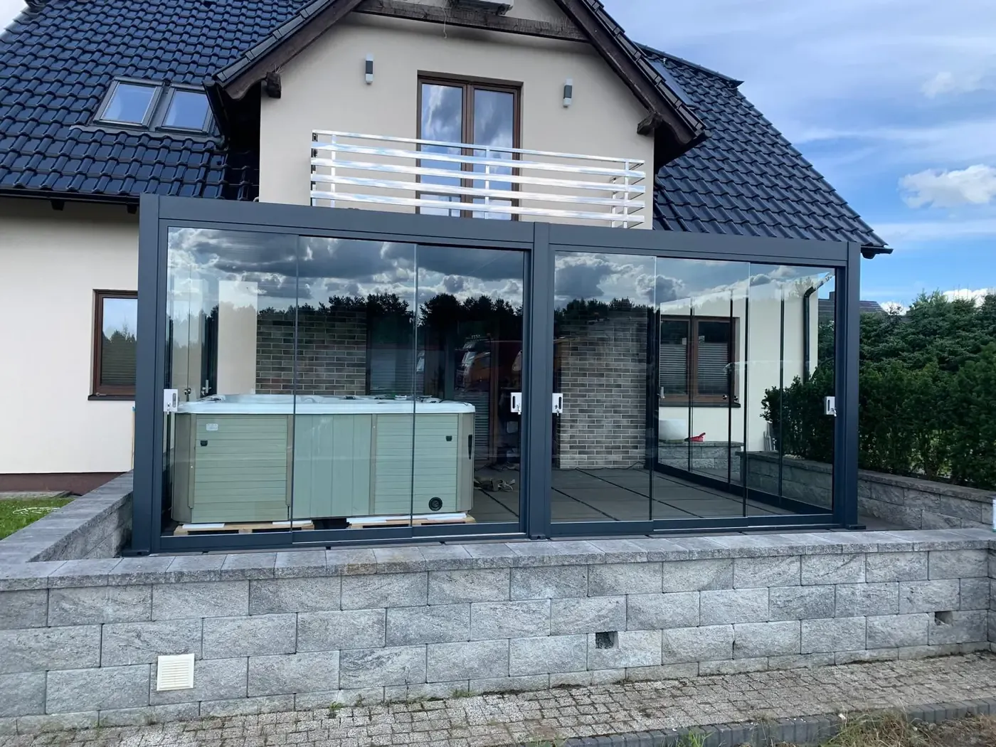 Pergola bioclimatique vitrée abritant un spa