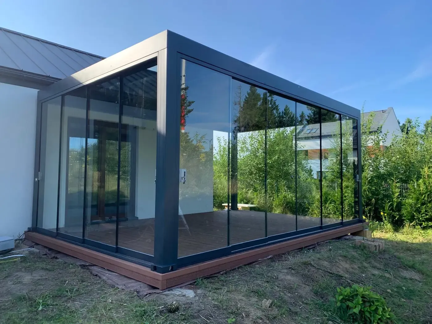 Pergola bioclimatique entièrement vitrée sur une terrasse